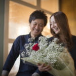 結婚記念日に花束を贈る夫と喜ぶ妻